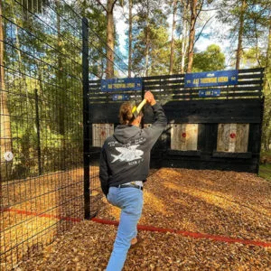 Girl prepares to throw axe at target