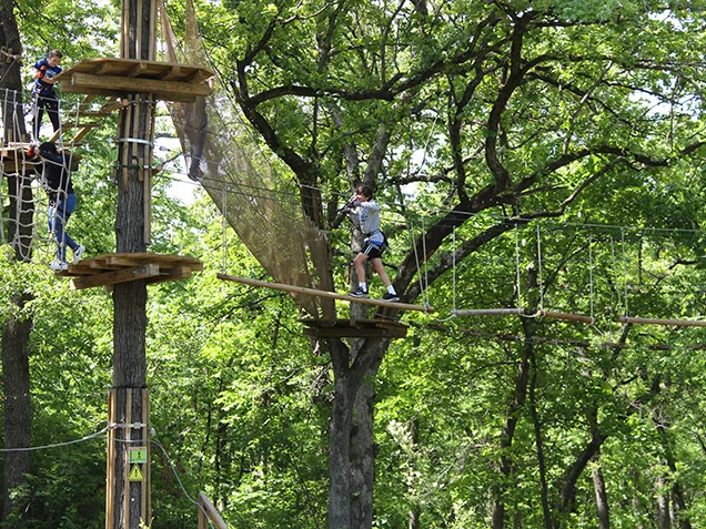 A young man enjoying Go Ape outdoor adventure ropes course Kansas City