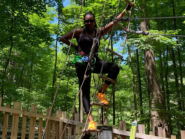 Woman enjoying Go Ape outdoor adventure ropes course Cleveland