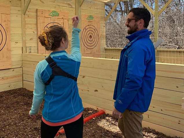 Woman demonstrating her axe throwing technique