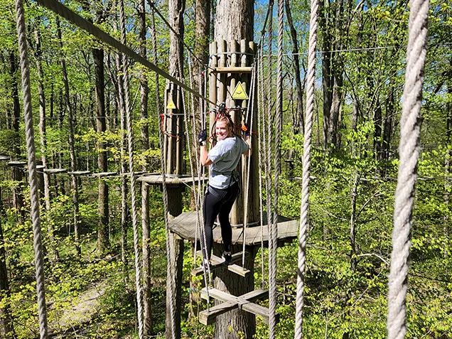 Woman having fun on Go Ape outdoor adventure ropes course Indianapolis