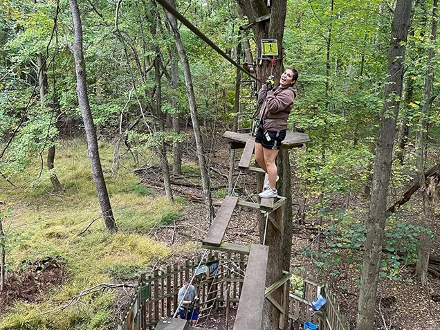 Woman enjoying Go Ape outdoor adventure ropes course Cleveland