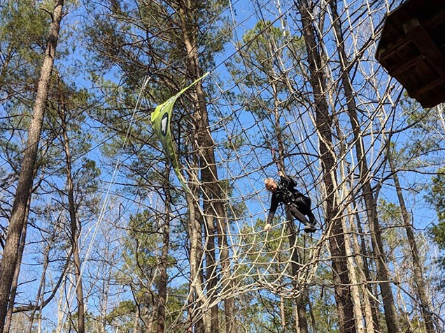 Boy climbs net after Tarzan swing