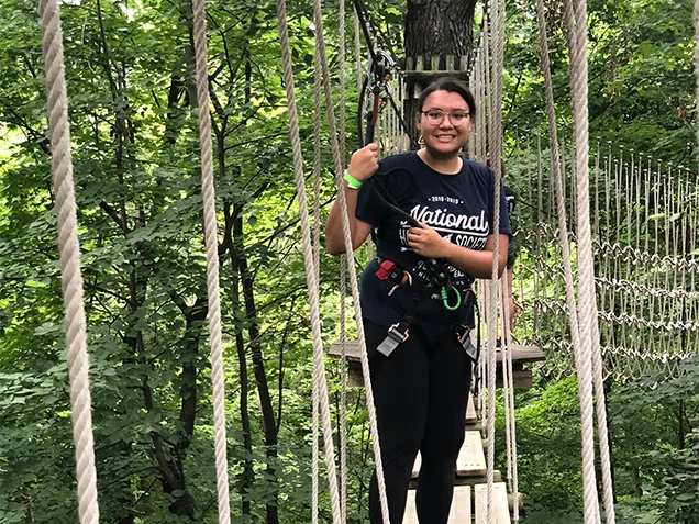Young woman smiles at Go Ape outdoor adventure ropes course St Louis