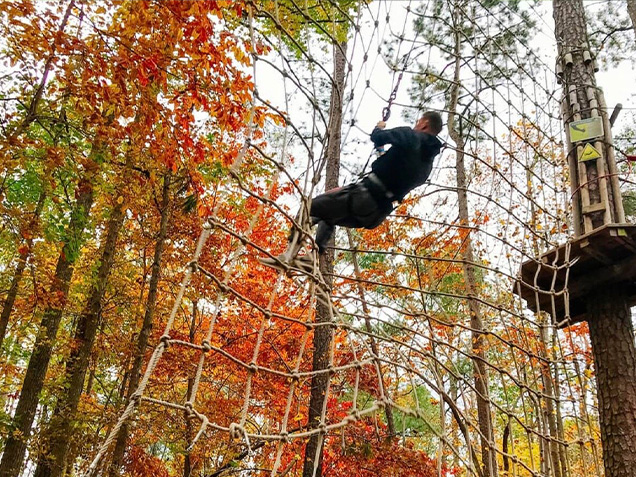 Man climbs net after tarzan swing