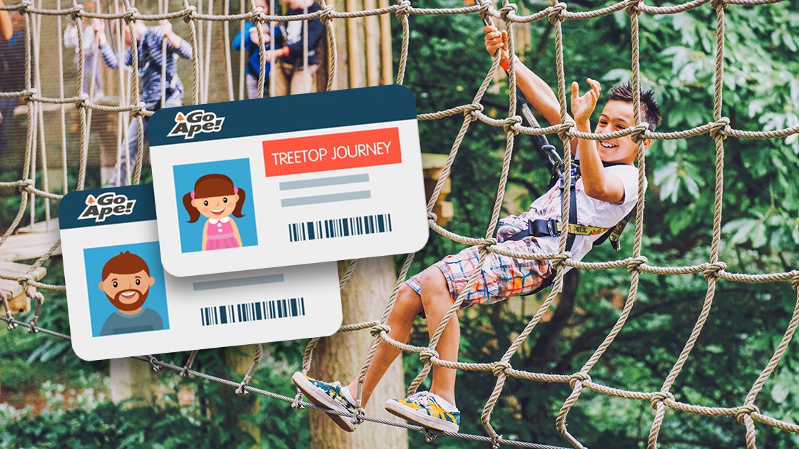 Young boy grabs suspended vertical cargo net after swinging on Tarzan swing