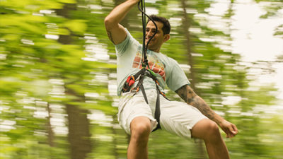 Man looks forward while rapidly descending a zipline