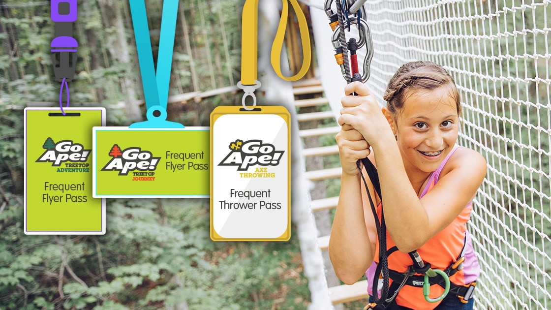Young girl clutches her safety lines while navigating a treetop bridge obstacle