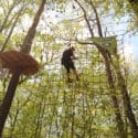 Instructor up in the trees closing the tarzan swing