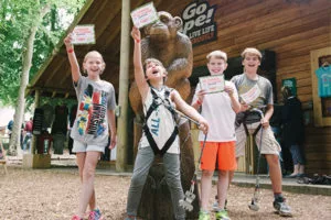 Young kids hold up certificates triumphantly