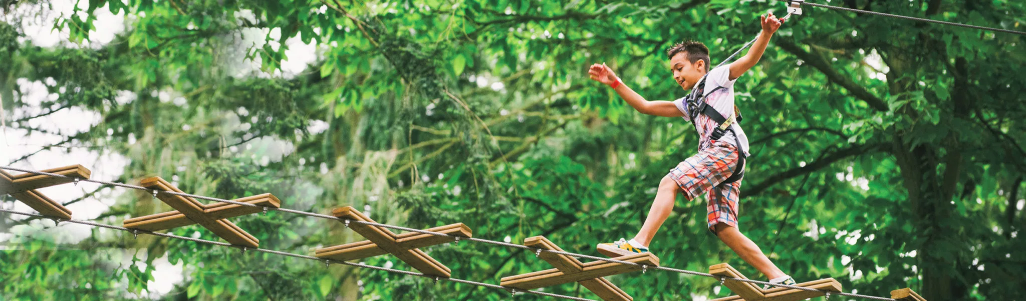 Young boy leaps across obstacle