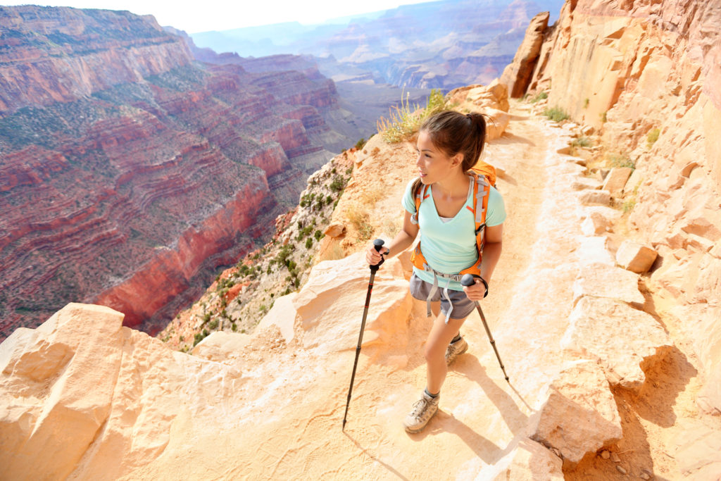 Hiker woman hiking in Grand Canyon walking with hiking poles.