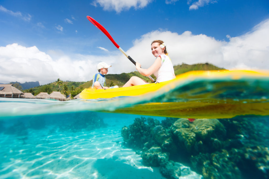 Boy and woman kayaking on the ocean