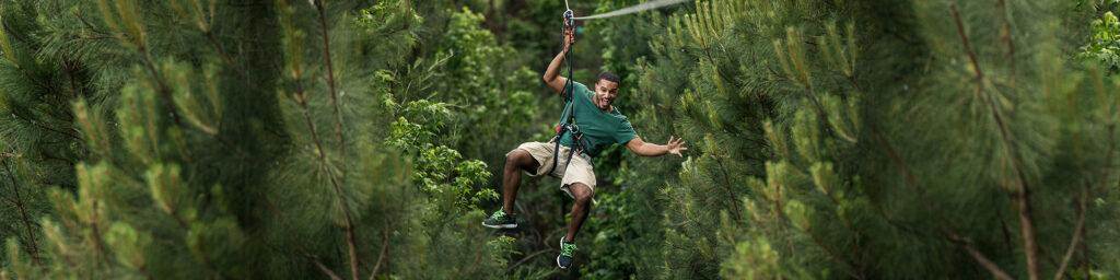 Person ziplining through treetops during a Go Ape outdoor adventure – perfect holiday gift experience