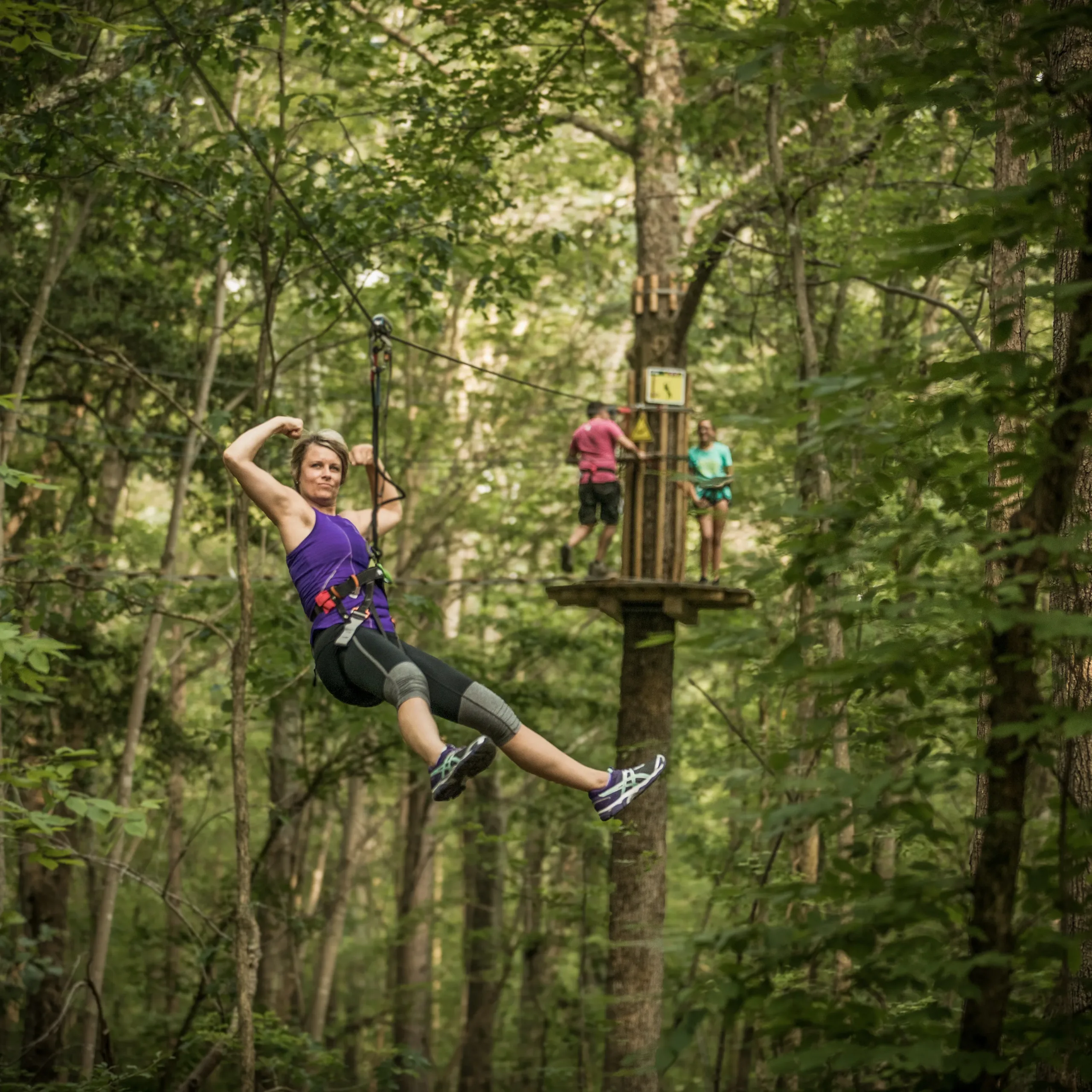 Train To Climb: Your Complete Go Ape Workout - A zipliner flexing her muscles